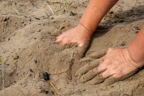 Wet hands in the sand.