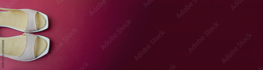 women's shoes of beige color on a red background. the shoes are removed from the top. banner for placement on the site women's shoes of beige color on a red background. the shoes are removed from the top. banner for placement on the site