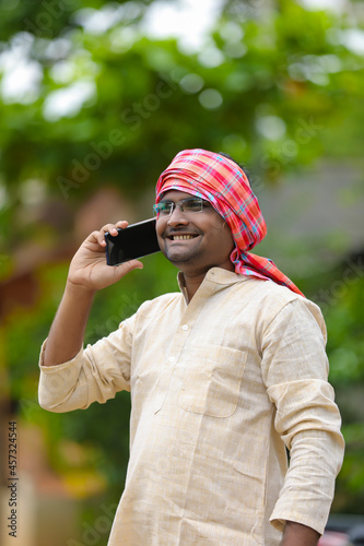 Indian farmer talking on smartphone at home.