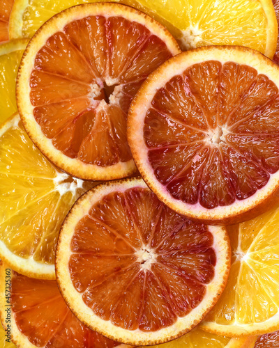 Slices of red and yellow oranges. Juicy citrus pulp. Close-up abstract background