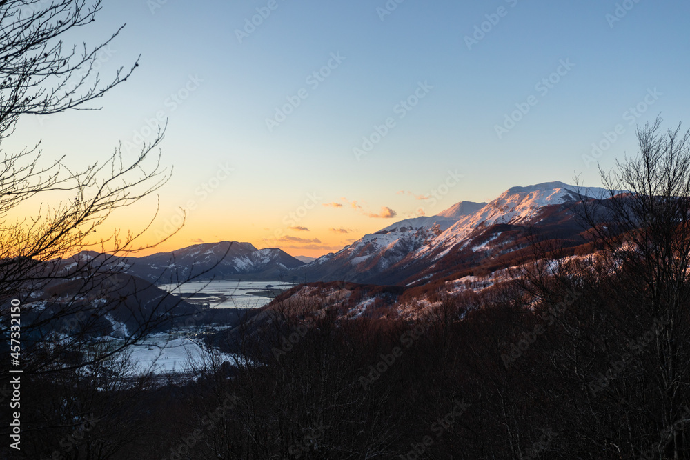 Sunset over Apennine mountains with trees in the foreground