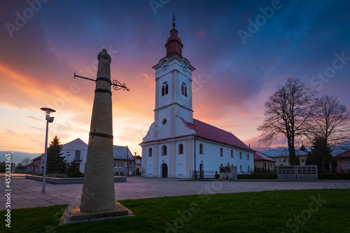 Church and whipping post in the main square of Sucany, Slovakia.
