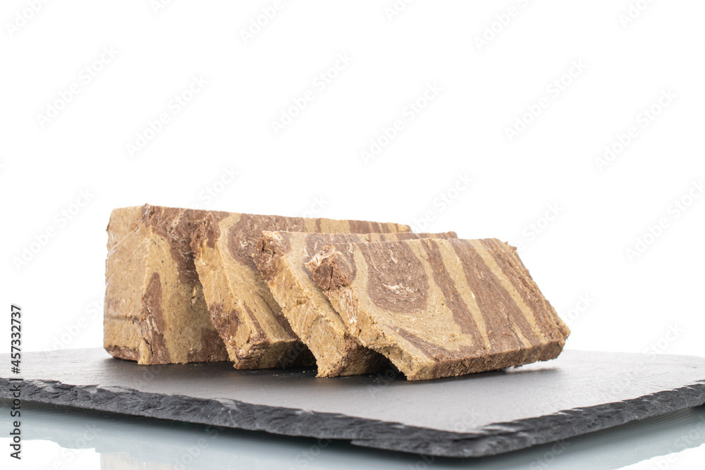 Pieces of sweet halva with chocolate on a slate stone, close-up, isolated on white. Pieces of sweet halva with chocolate on a slate stone, close-up, isolated on white.