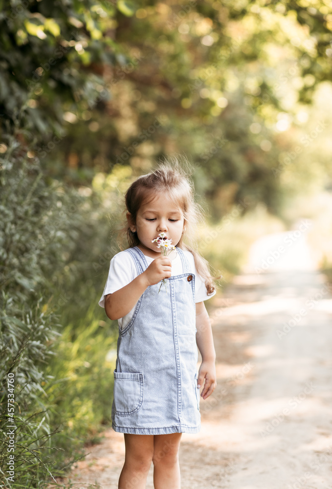 Positive charming little girl enjoying summer sunny day, expression emotions, having fun, happy child walking in summer day Positive charming little girl enjoying summer sunny day, expression emotions, having fun, happy child walking in summer day