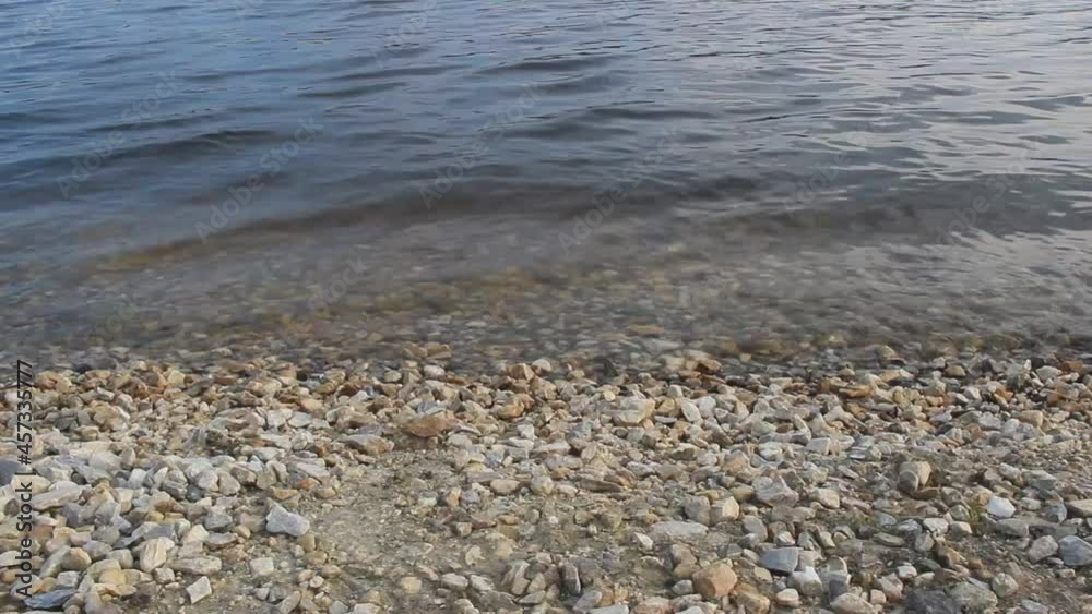 Water waves run over the rocky shore Water waves run over the rocky shore
