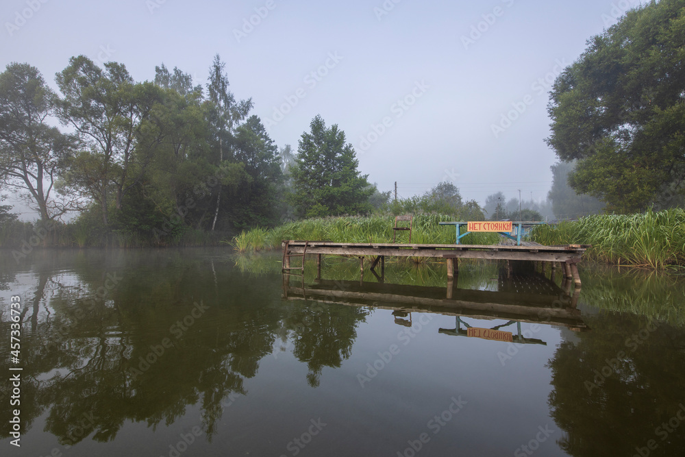 Obraz premium Sunrise fog river landscape. River on an early summer morning at dawn. Fogs lit by the gentle sun.
