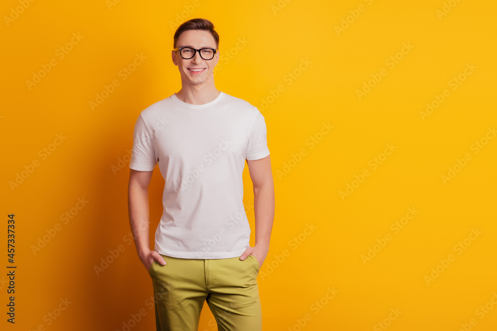 Portrait of handsome cheerful good-looking guy hands pockets posing on yellow background Portrait of handsome cheerful good-looking guy hands pockets posing on yellow background