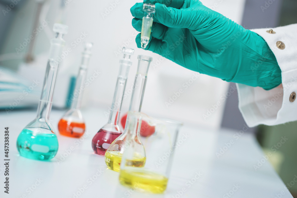 Fototapeta premium Hands of a chemical laboratory employee with test tubes close-up.