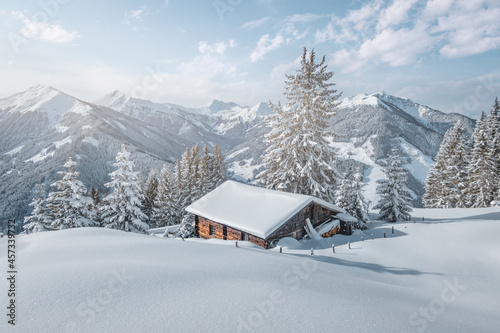 Beautiful winter mountain landscape with snowcapped wooden hut