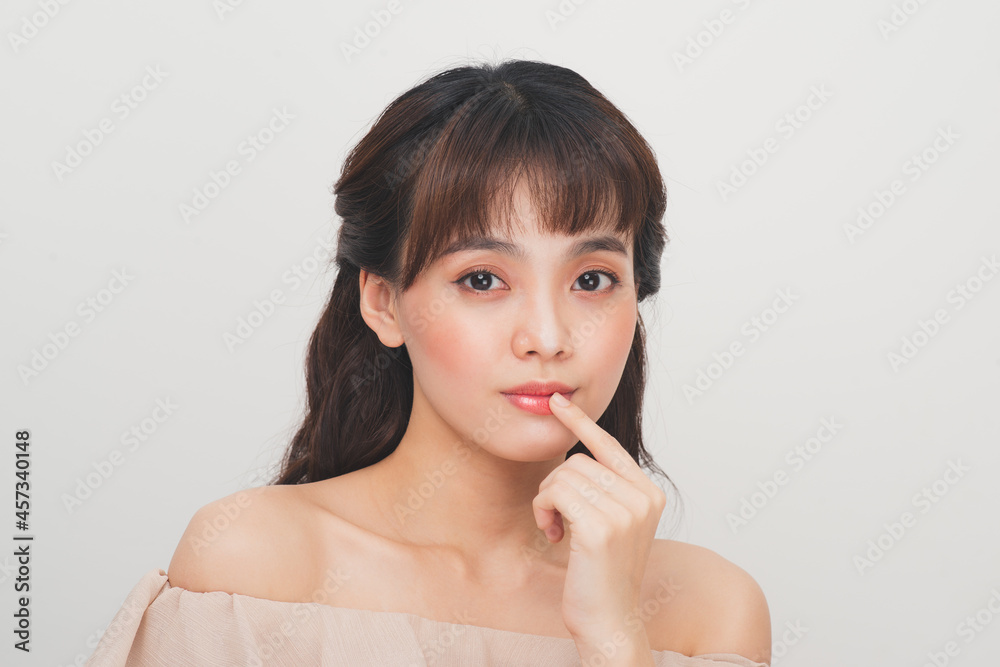 Attractive young asian woman applying lip balm on a white background Attractive young asian woman applying lip balm on a white background
