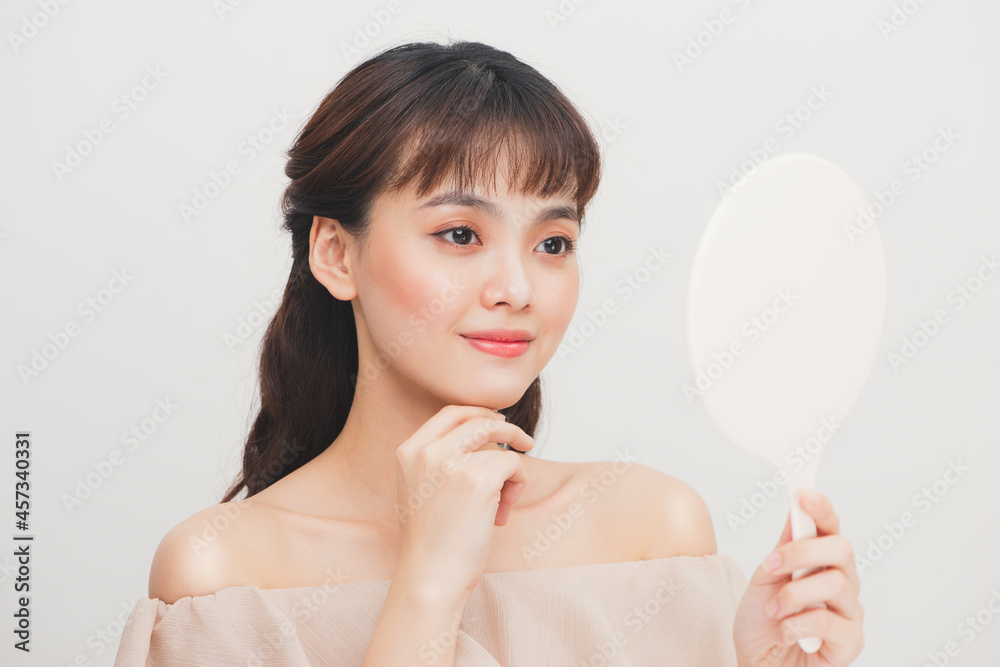 Facial beauty. Beautiful smiling girl with natural makeup looking in mirror Facial beauty. Beautiful smiling girl with natural makeup looking in mirror