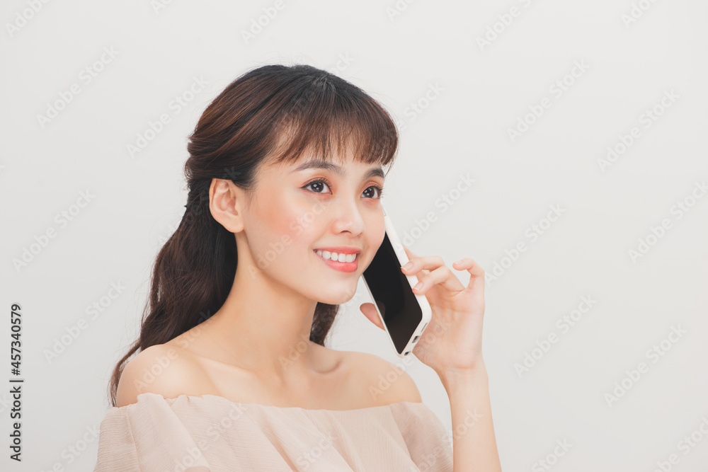 Portrait of asian attractive woman girl talking on mobile phone over white background Portrait of asian attractive woman girl talking on mobile phone over white background