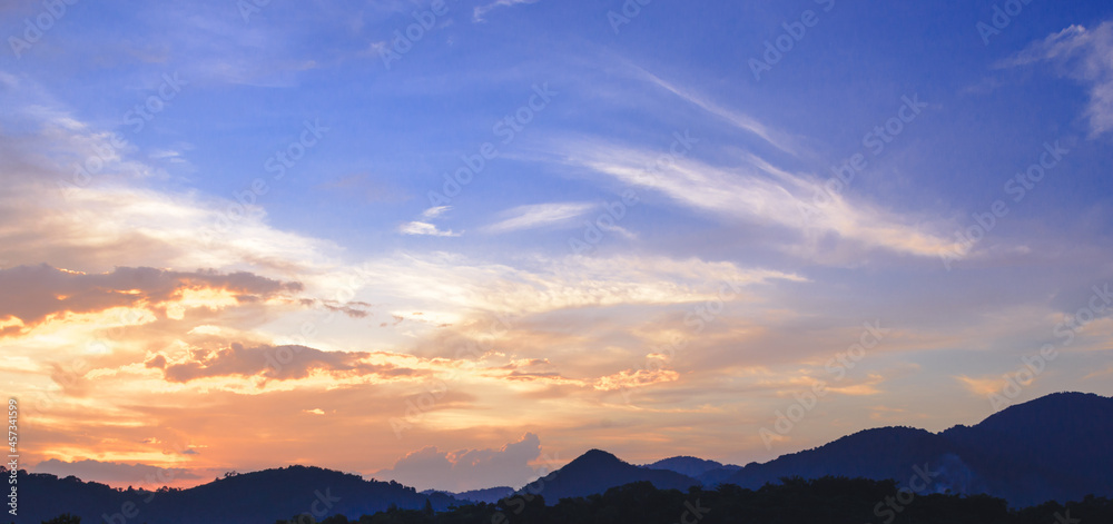 silhouette mountain with attractive background, sunset with vivid twilight sky, in panorama