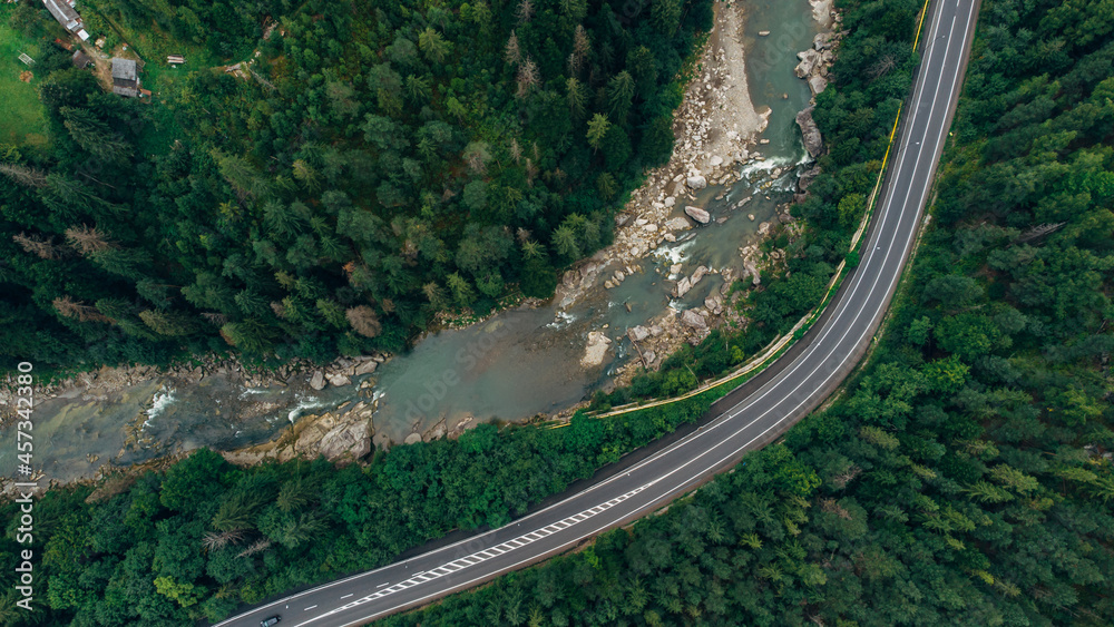 Beautiful aerial view of the road with mountains and forest, road and river, shot from above, carpathians, Ukraine