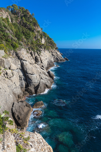 Rocky coastline and cliffs with waves crashing. Mediterranean Ligurian Sea, Italy. Natural landscape.