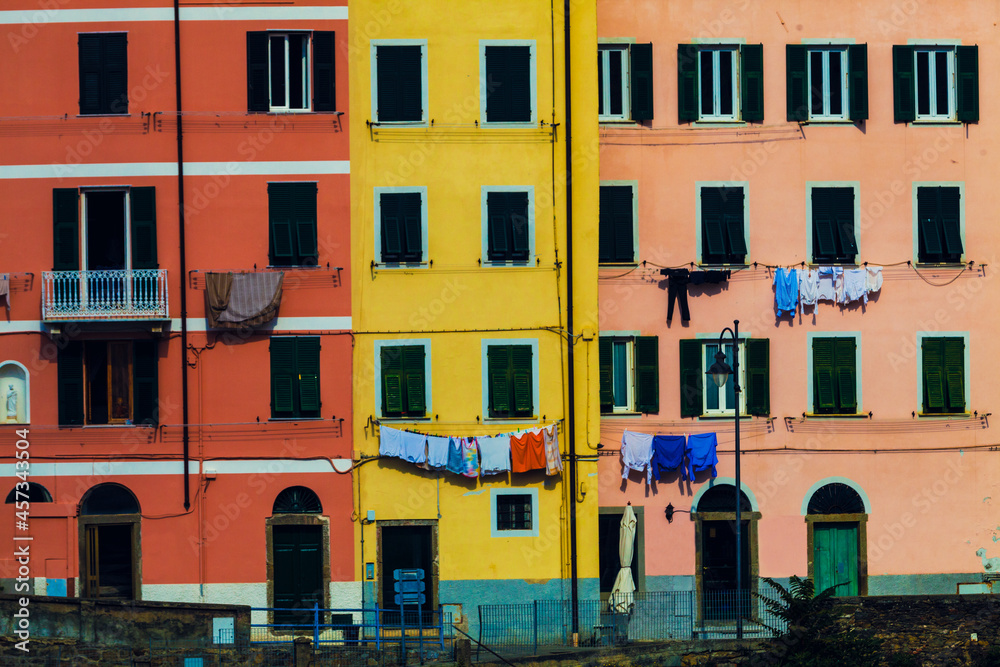 Colorful dwellings. Full background with colorful italian buildings with hanging clothes. Riomaggiore, Cinque Terre National Park, Italy.