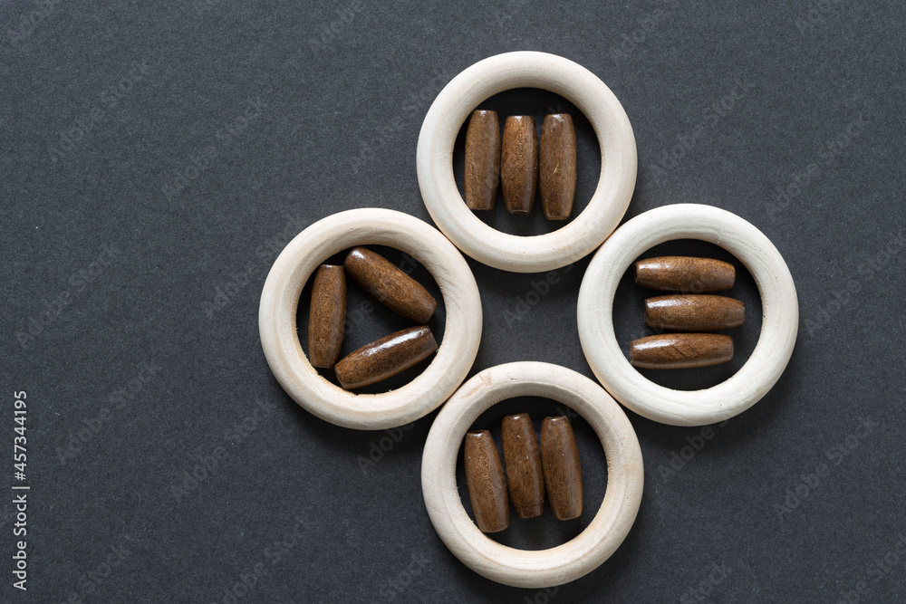 plain wooden rings with beads on gray paper background
