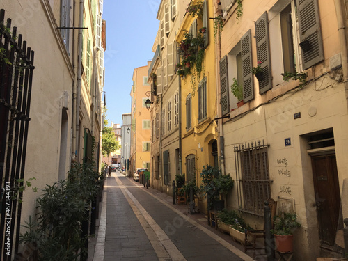 Pastel coloured residential buildings on a calm and friendly street on a summer sunny day in Le Panier - Marseille's oldest and most visited neighborhood.