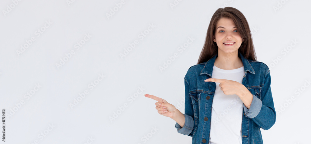 Obraz premium Happy beautiful young woman showing way with fingers