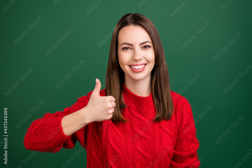Photo portrait girl in red pullover showing thumb-up sign smiling overjoyed laughing isolated green color background Photo portrait girl in red pullover showing thumb-up sign smiling overjoyed laughing isolated green color background