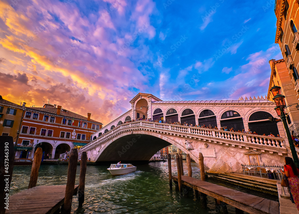Sunset view of famous bridge of Rialto or ponte di Rialto over Grand Canal, Venice, Italy. Iconic travel destination of UNESCO world heritage city Sunset view of famous bridge of Rialto or ponte di Rialto over Grand Canal, Venice, Italy. Iconic travel destination of UNESCO world heritage city