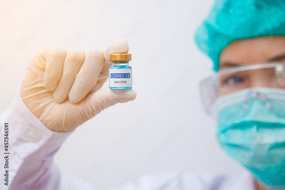 Close up on Vaccine Asian doctor, scientist wearing gloves holding a Vaccine syringe