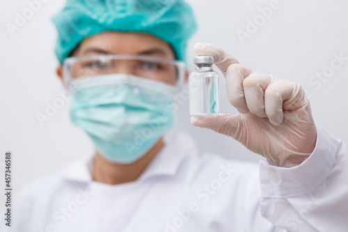 Close up on Vaccine Asian doctor, scientist wearing gloves holding a Vaccine syringe