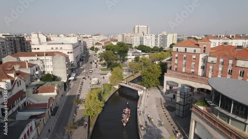 Aveiro city skyline with huge tourist canoe sailing through downtown canal, aerial view