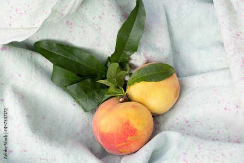 peaches with leaves on canvas cloth photo