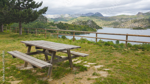 Tranquila area de descanso donde hay bancos y mesas de madera donde disfrutar de un picnic y admirar el paisaje montañoso que rodea al embalse de Barrios de Luna en la provincia de León. España.