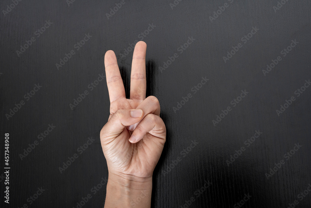 Closeup of female hand showing victory sign. Closeup of female hand showing victory sign.