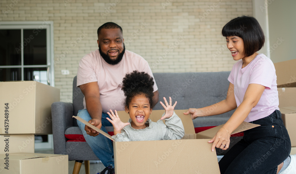 Mixed Race families are sitting on the sofa for rest after moving to a new house on the first day after buying real estate. Concept of starting a new life for a new family. Mixed Race families are sitting on the sofa for rest after moving to a new house on the first day after buying real estate. Concept of starting a new life for a new family.