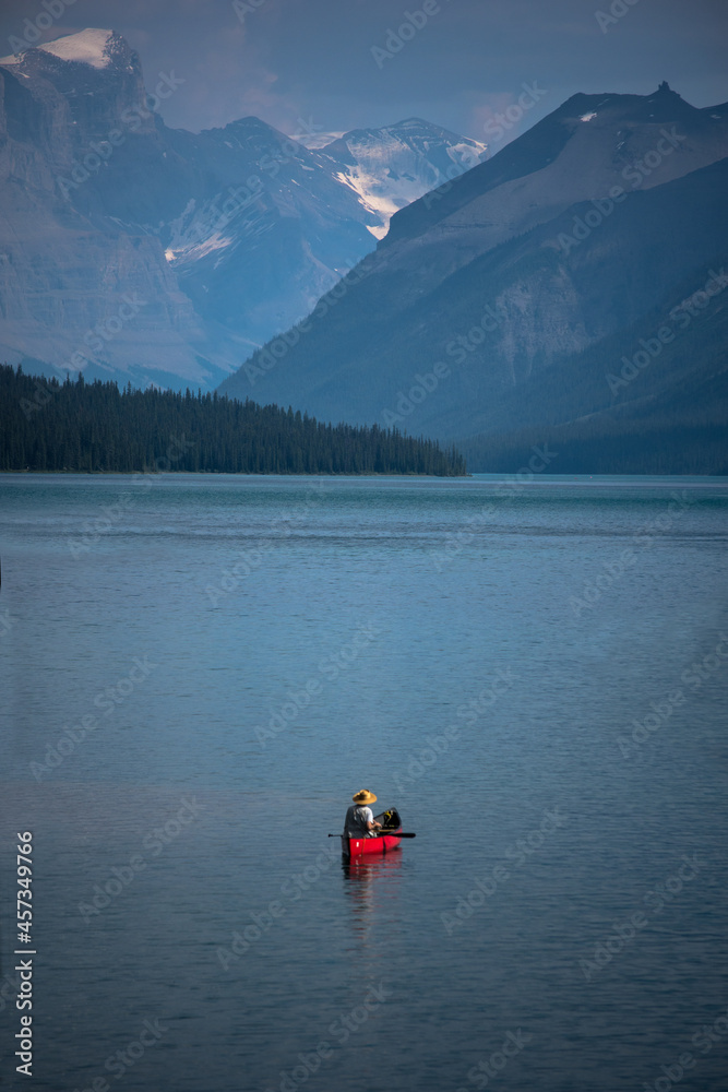 Single person in red canoe on mountain lake