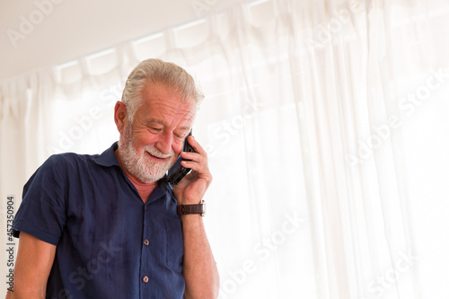 Senior man using mobile phone at home