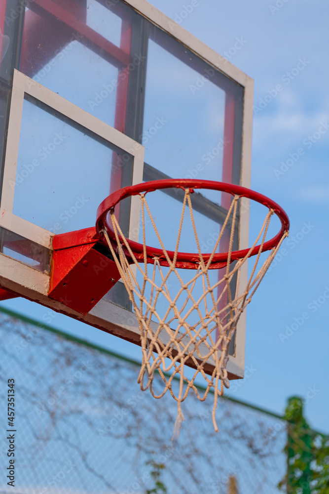 Red basketball hoop with net on a background of blue sky. Sport concept