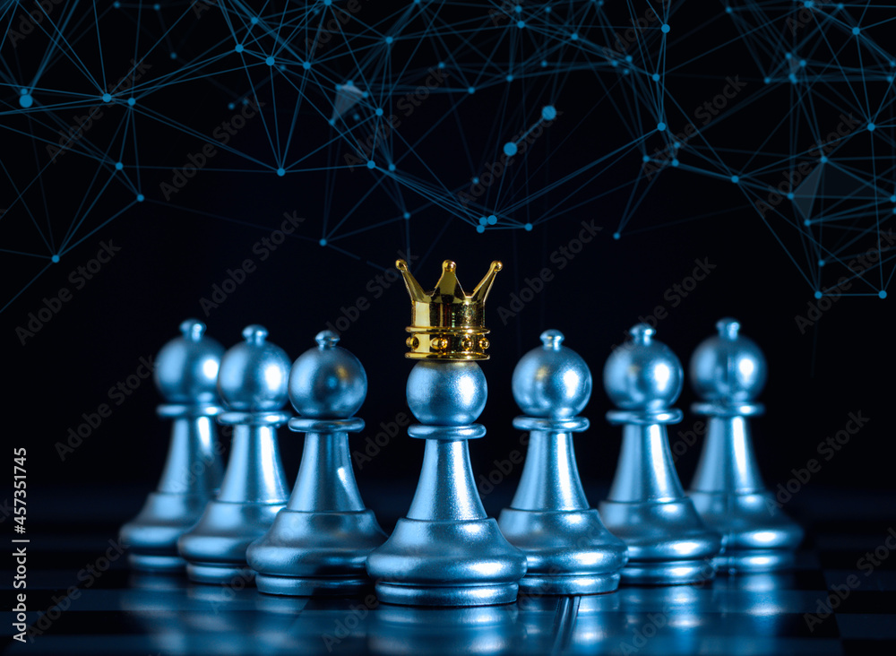 Fotka „A silver pawn standing crowned in battle chess game on board with  gold chess background. successfully in the competition with technology  network background. Management or leadership strategy concept.“ ze služby  Stock