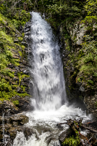 Wasserfall mit Felsen und gr  nen B  umen