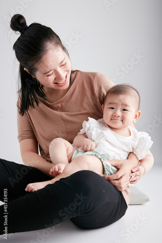 Cute Asian baby lying in mother's arms