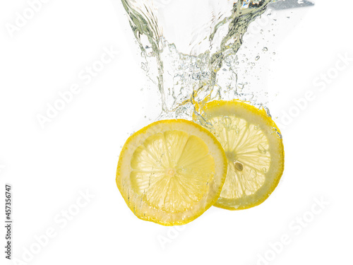two lemon slices fall under the water with a splash