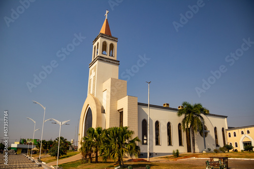 Fachada da Paróquia de São Benedito na cidade de Nerópolis com céu azul ao fundo.