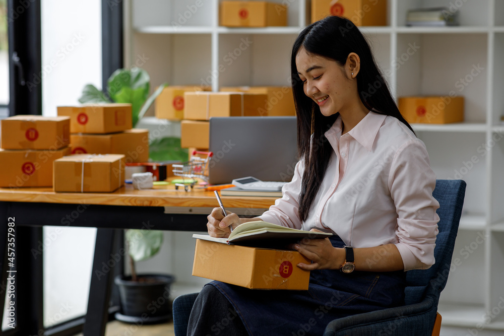 Starting Small business entrepreneur SME freelance,Portrait young woman working at home office, BOX,smartphone,laptop, online, marketing, packaging, delivery, b2b,SME, e-commerce concept. Starting Small business entrepreneur SME freelance,Portrait young woman working at home office, BOX,smartphone,laptop, online, marketing, packaging, delivery, b2b,SME, e-commerce concept.