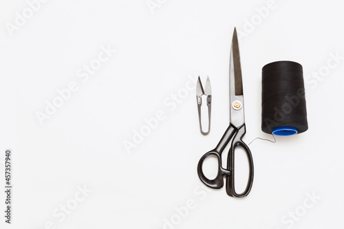 sewing instruments on a gray background. scissors and threads for sewing