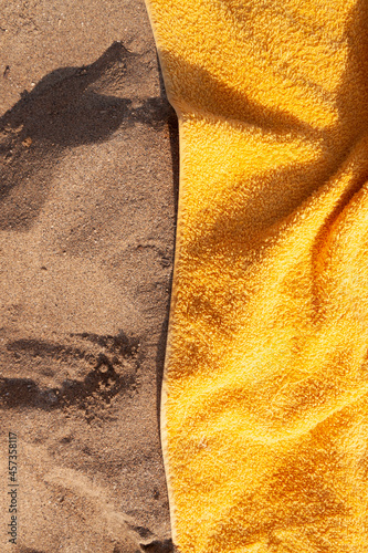 Texture of sand and towel cloth, of intense color, extended to the sun, on Arrigunaga beach, near Bidezabal, Basque Country, Spain photo