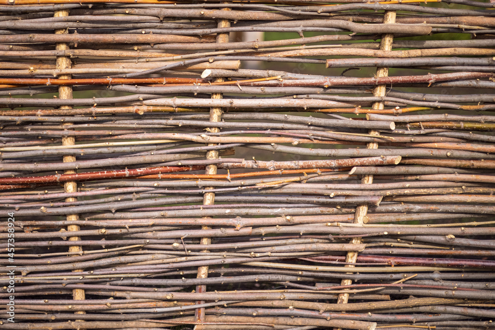 Wicker fence made of branches in the village beautiful texture.