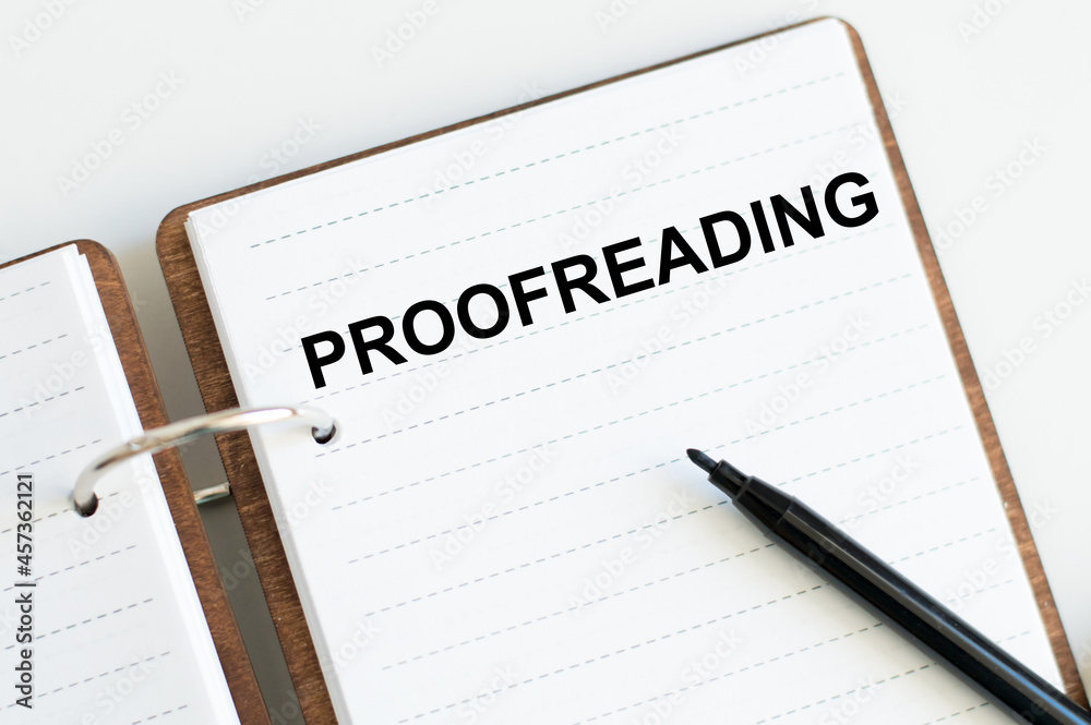 Text Proofreading is written on a notepad near a black marker Text Proofreading is written on a notepad near a black marker