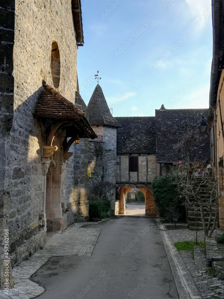 Balade dans une des rues du village de Loubressac avec le porche de l'église, dans le Lot