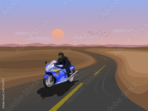 Man riding a big bike on a highway with mountains and sunset in the background.