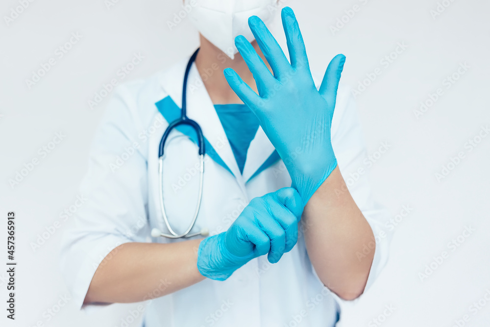 A woman doctor wears latex gloves on her hand. Preparation for surgery. A medical worker in uniform. A woman doctor wears latex gloves on her hand. Preparation for surgery. A medical worker in uniform.