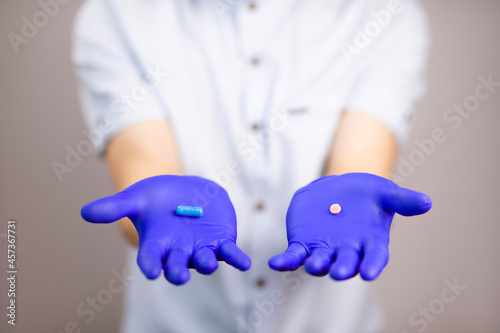 The doctor holds out his hands with pills. Tablets to choose from. Protection from disease. Treatment. Medicines in hand. The guy offers pills.