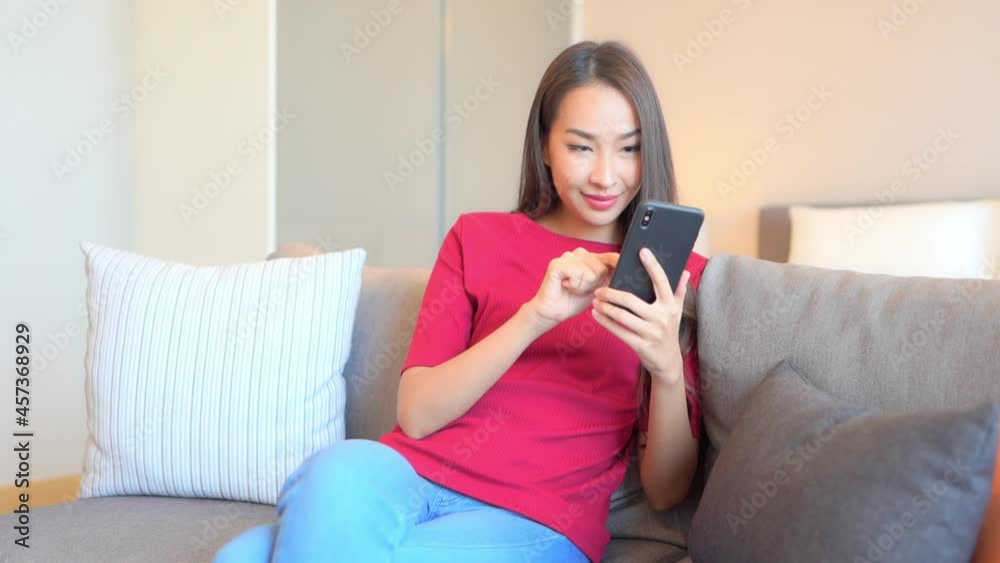 Beautiful Young Asian Woman Texting on Smartphone in Privacy of Home, Full Frame Slow Motion Beautiful Young Asian Woman Texting on Smartphone in Privacy of Home, Full Frame Slow Motion